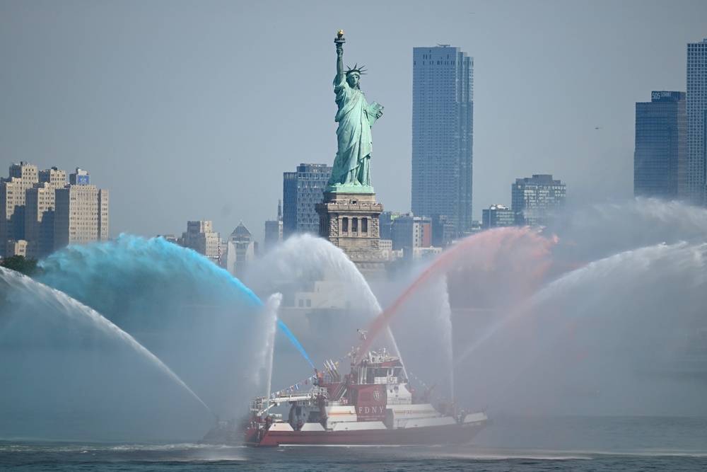 An FDNY boat sprays its hoses in tribute in front of the Statue of Liberty ahead of an international parade of tall sailing ships in New York Harbor on July 04, 2026 in New York City (Vincent Alban/Getty Images)