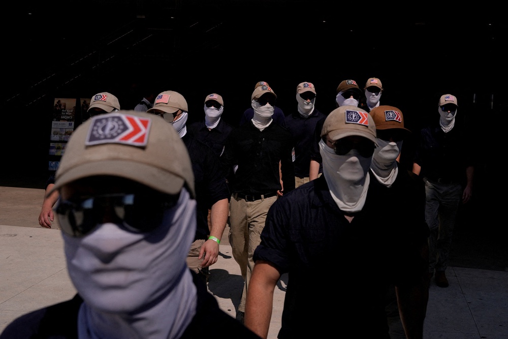 Members of the group, which espouses anti-immigrant views and believes multiracial democracies are an existential threat to white people, typically wear masks and sunglasses to cover their faces (Reuters)