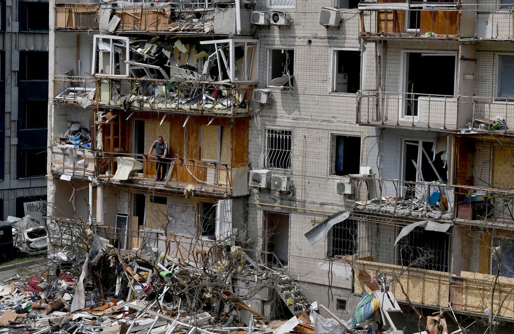 A local resident stands on the balcony of his flat in a residential building damaged by a Russian air attack Kyiv (AFP via Getty Images)