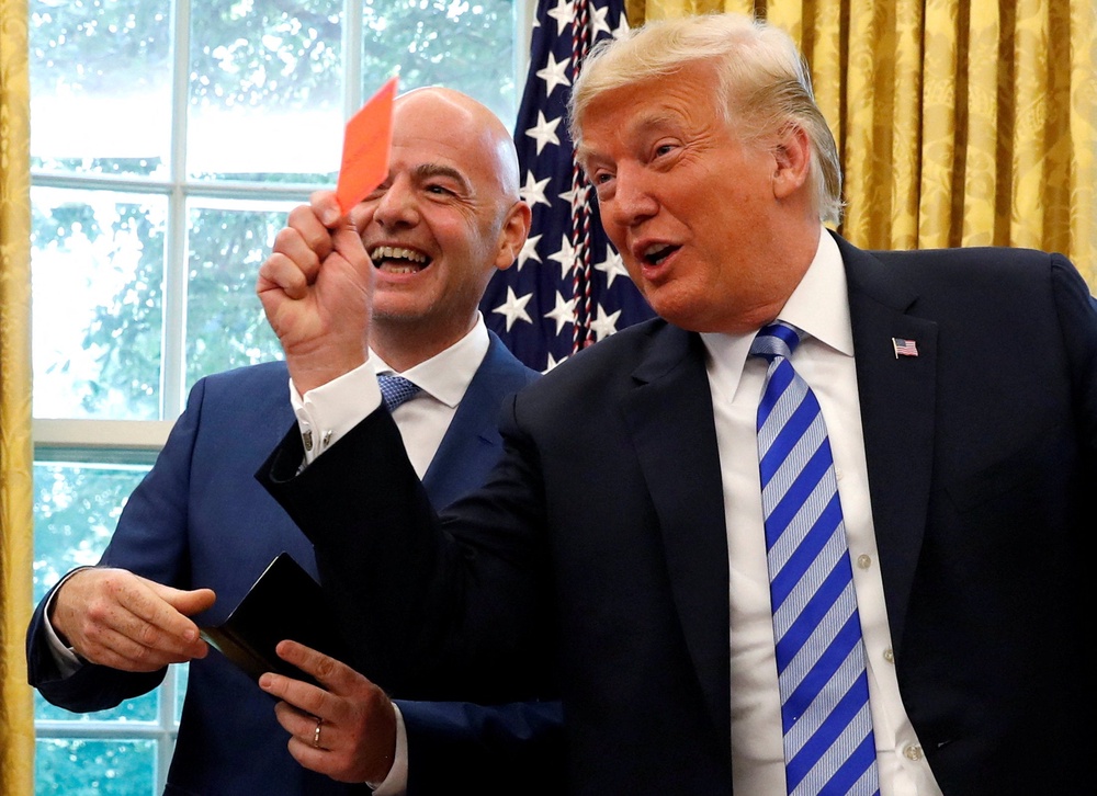 US President Donald Trump holds up a red card as he meets with Fifa boss Gianni Infantino (Reuters)