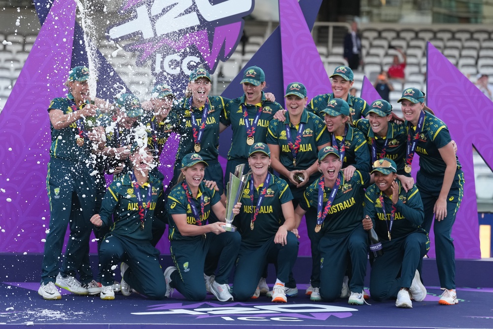 The Australia team celebrate on the podium with the trophy after winning the Women's T20 Cricket World Cup (AP)