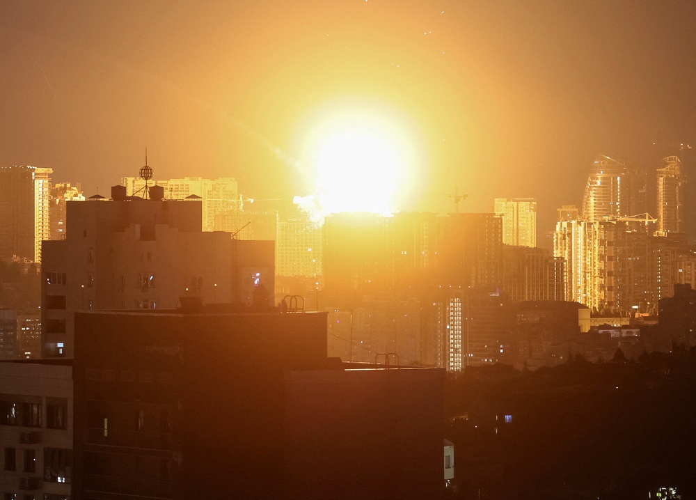 An explosion lights up the sky over the city during a Russian missile and drone strike in Kyiv (Reuters)
