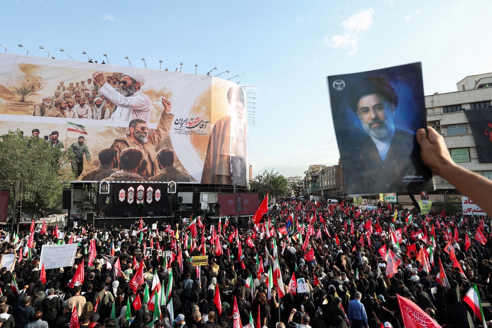 A mourner holds an image of Iran's Supreme Leader Mojtaba Khamenei as people gather for a funeral procession for Iran's late Supreme Leader Ayatollah Ali Khamenei (Reuters)