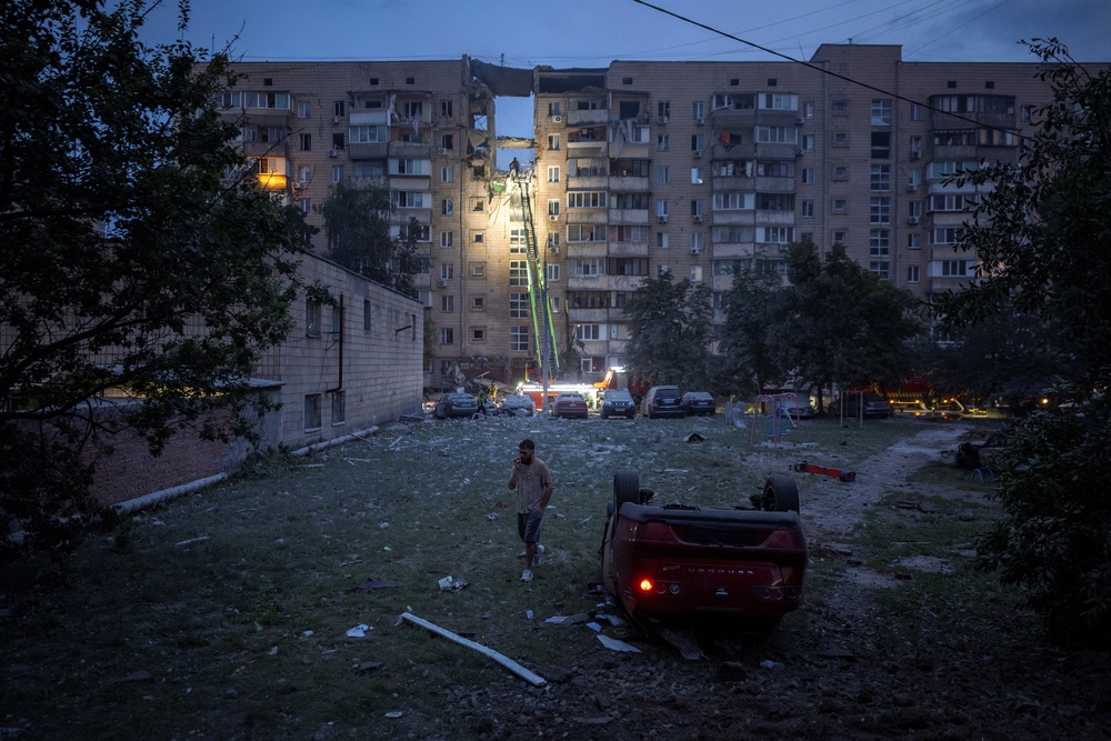 A flipped-over car lies near an apartment building, which was heavily damaged during Russian missile and drone strikes, in Kyiv (Reuters)