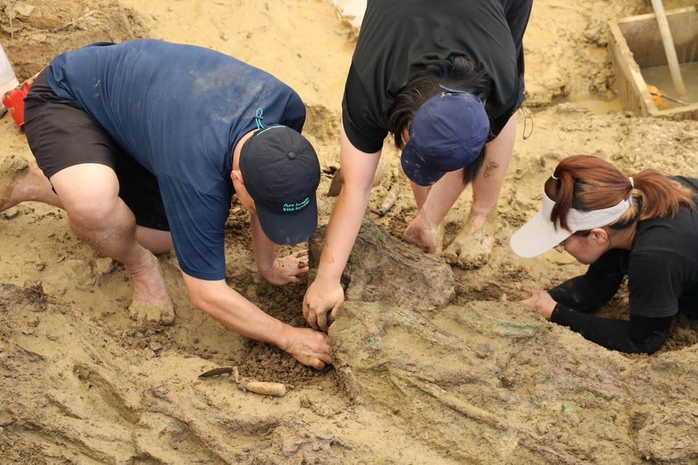 Archaeologists are pictured with human bones during an ongoing dig at the Don Yai Thong archeological site in Phetchaburi province, Thailand (AP)