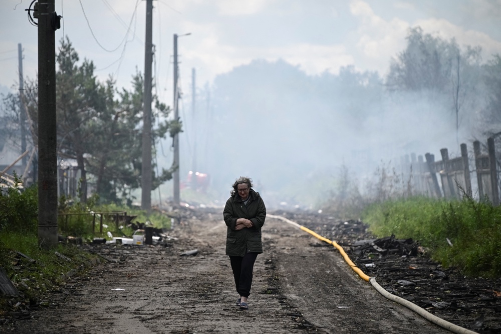 A resident walks on a street at a site of a Russian attack near Kyiv (Reuters)
