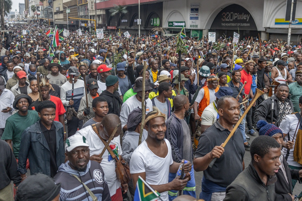 Members of the Zulu regiment known as the 'Amabutho' chant slogans as they march during a demonstration by the 