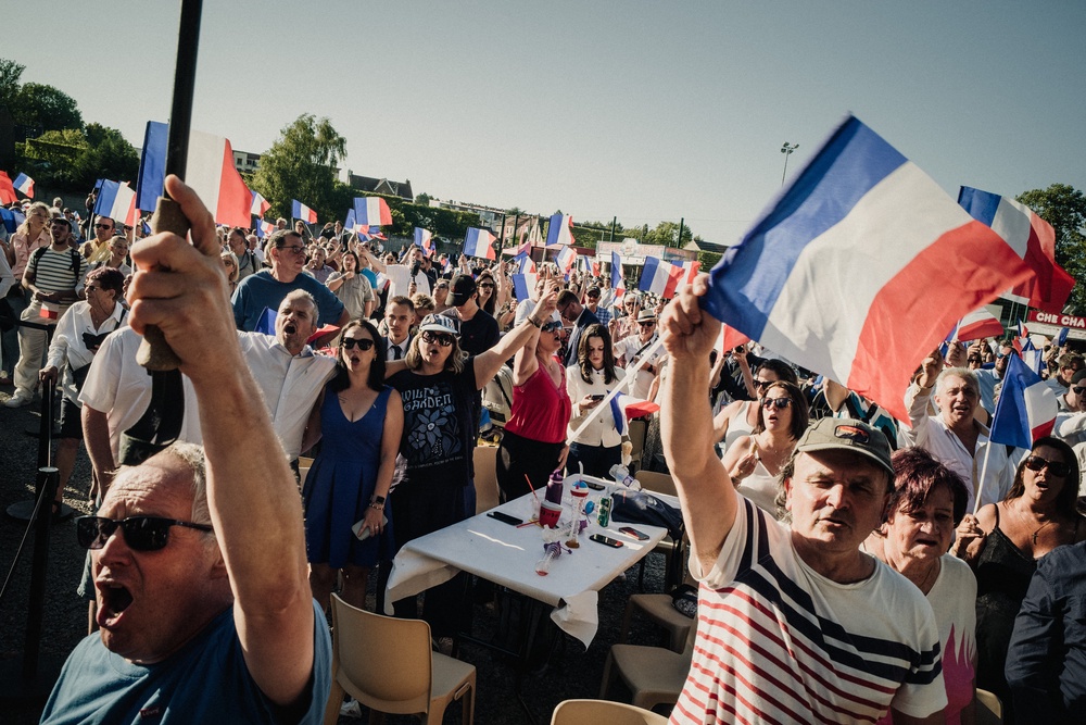 A crowd waves French flags during an event organised by the National Rally in Lievin on 4 July (AFP/Getty)