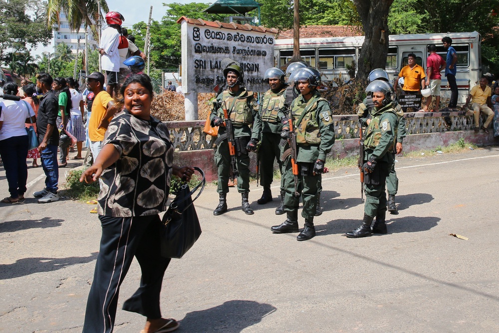 Security personnel stand guard outside a prison where deadly clashes broke out on Sunday, in Negombo (AP)
