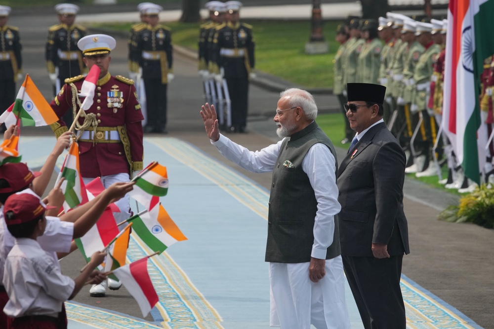 India's Prime Minister Narendra Modi, center, waves at school children waving national flags as Indonesia's President Prabowo Subianto, right, looks on during the welcoming ceremony ahead of their meeting at Merdeka Palace in Jakarta, Indonesia (AP)