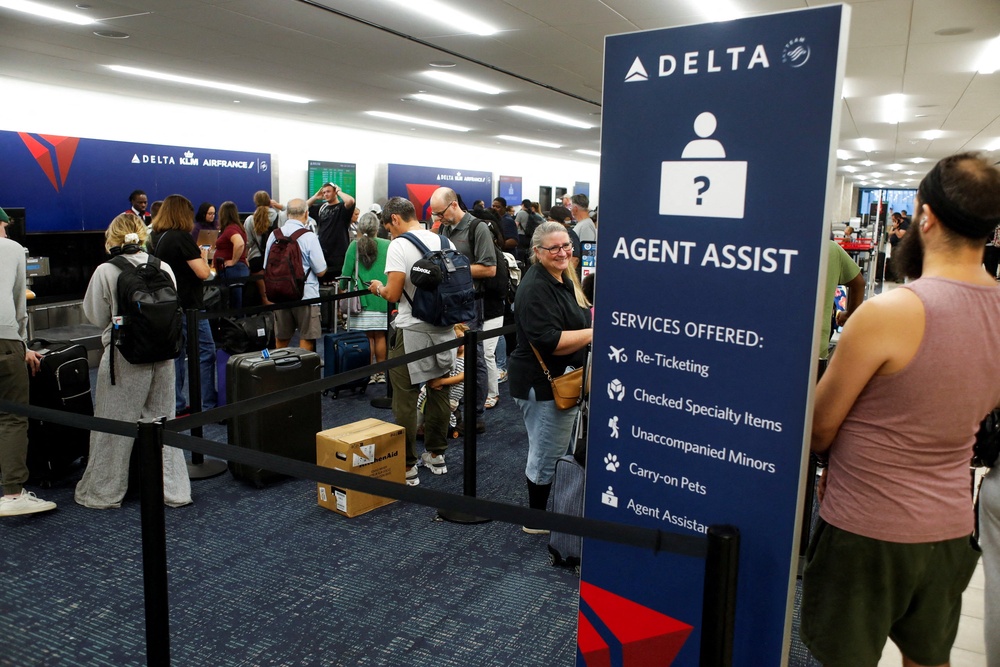 Airline passengers wait in line at the Delta, KLM, and Air France ticketing counters (Reuters)