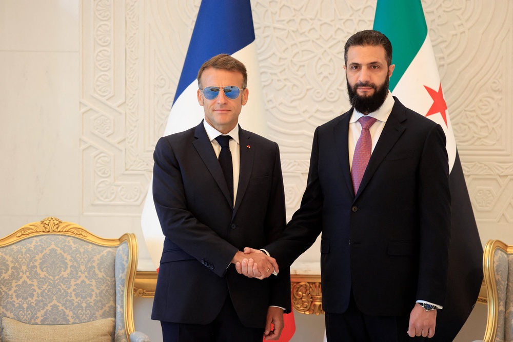 France's President Emmanuel Macron (L) shakes hands with Syrian President Ahmed al-Sharaa ahead of their meeting at the People's Palace in Damascus (AFP/Getty)