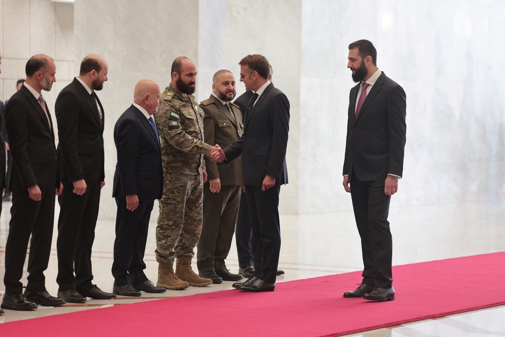 France's President Emmanuel Macron meets a delegation as Syrian President Ahmed Al-Sharaa receives Macron at the People's Palace in Damascus (Reuters)
