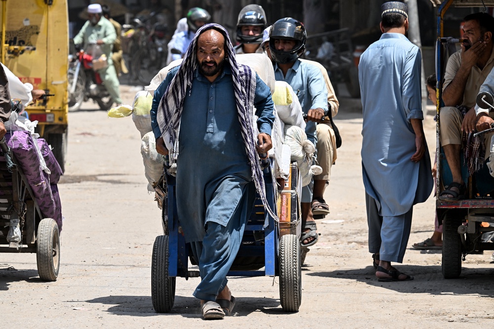 A labourer shields his head with a cloth as he hauls a loaded cart amid a heatwave in Rawalpindi, Pakistan (AFP/Getty)