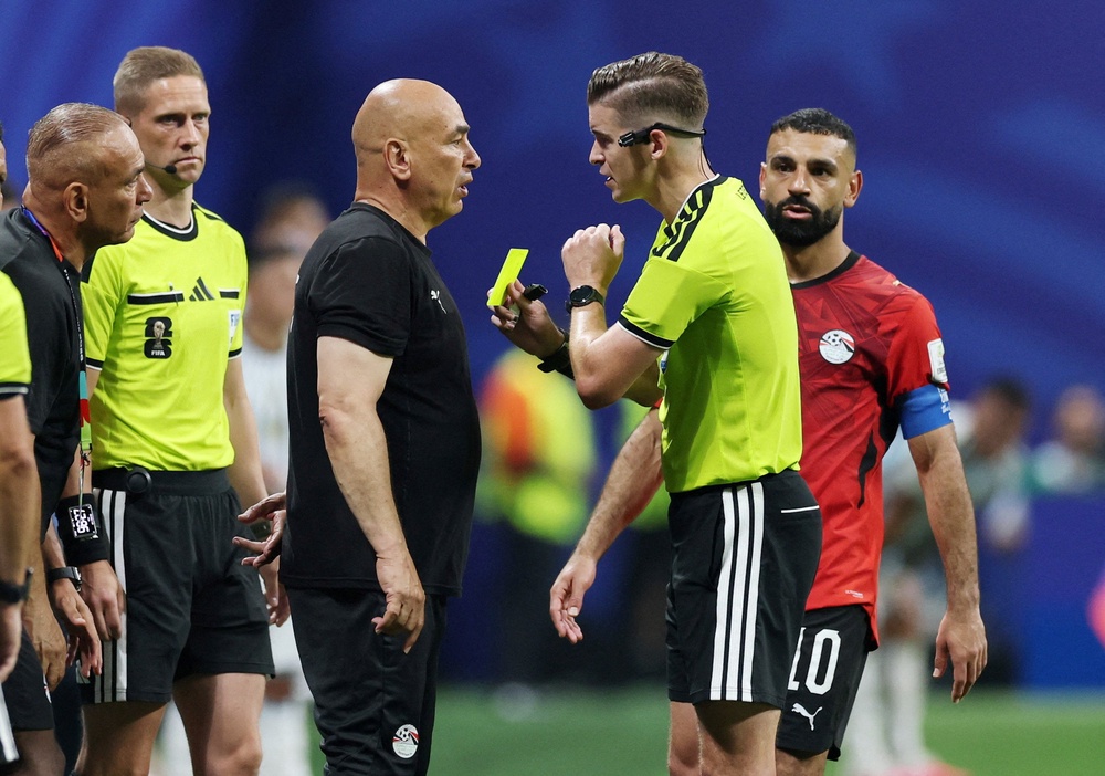Egypt coach Hossam Hassan is shown a yellow card by referee Francois Letexier (Reuters)