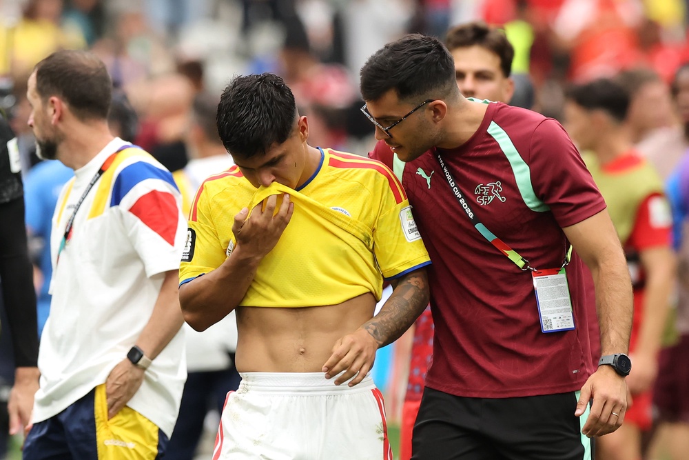 Juan Quintero #20 of Colombia is consoled by a team staff of Switzerland (Getty)