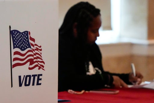 A Fulton County staff member works as people vote in a runoff election, Tuesday, June 16, 2026, in Atlanta (AP)