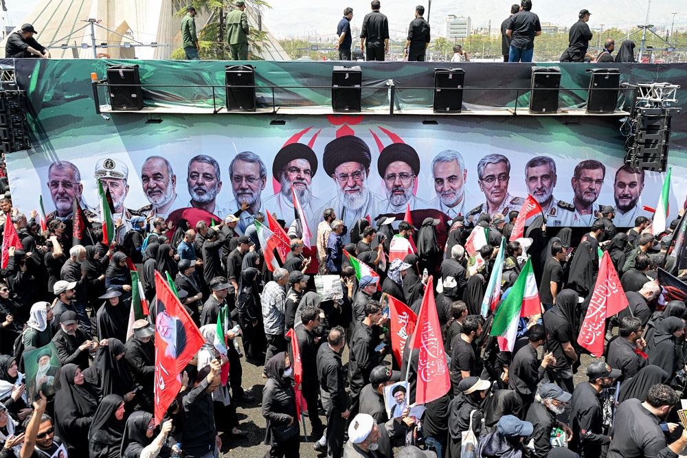 Mourners gather around one of the vehicles in the funeral procession for Iran's slain Supreme Leader Ali Khamenei at Azadi Square in Tehran on July 6, 2026 (AFP/Getty)