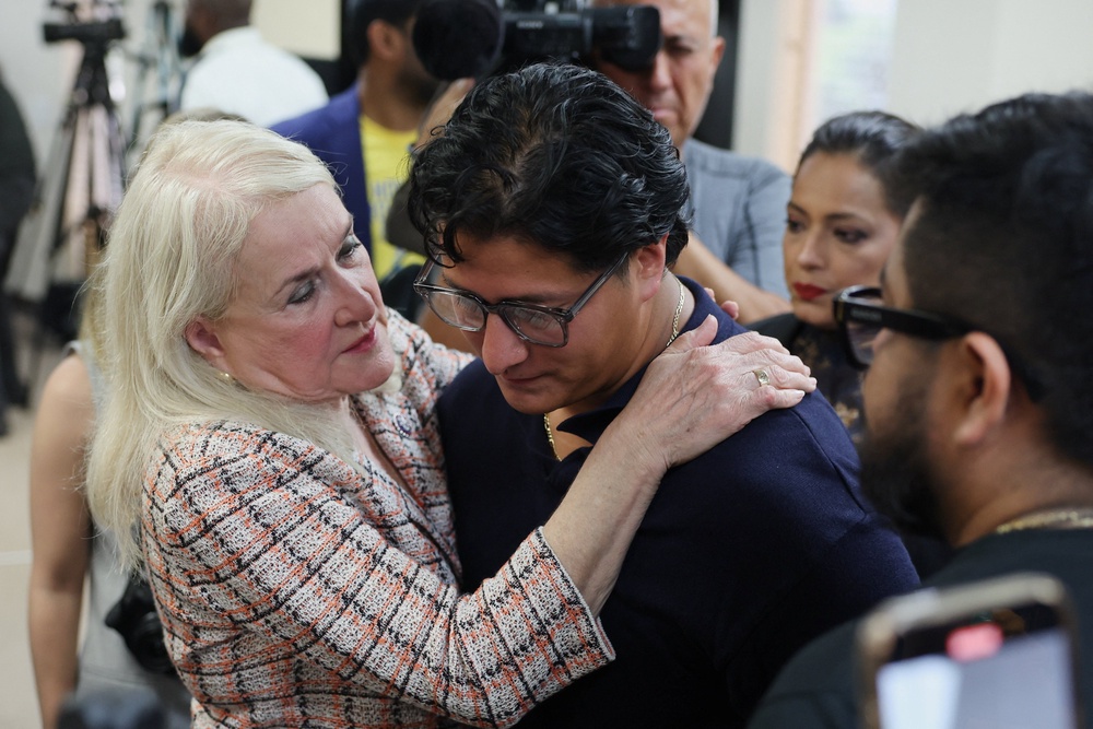 Ronaldo Salgado, son of Lorenzo Salgado Araujo, who was fatally shot by an ICE agent, is embraced Rep. Sylvia Garcia (Reuters)