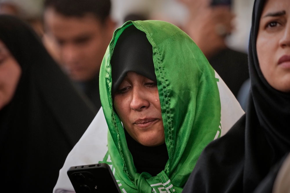 A mourner, draped in an Iranian flag, sheds a tear during funeral prayers for the late Iranian Supreme Leader Ayatollah Ali Khamenei (Hadi Mizban/AP) (AP)