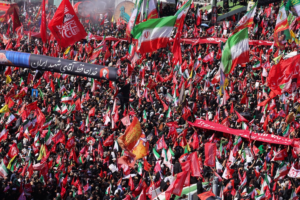 Mourners march with flags and banners during a funeral procession for Khamenei (AFP/Getty)