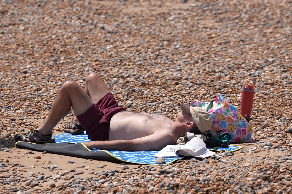 People enjoy the hot weather on Hastings beach (Gareth Fuller/PA) (PA Wire)