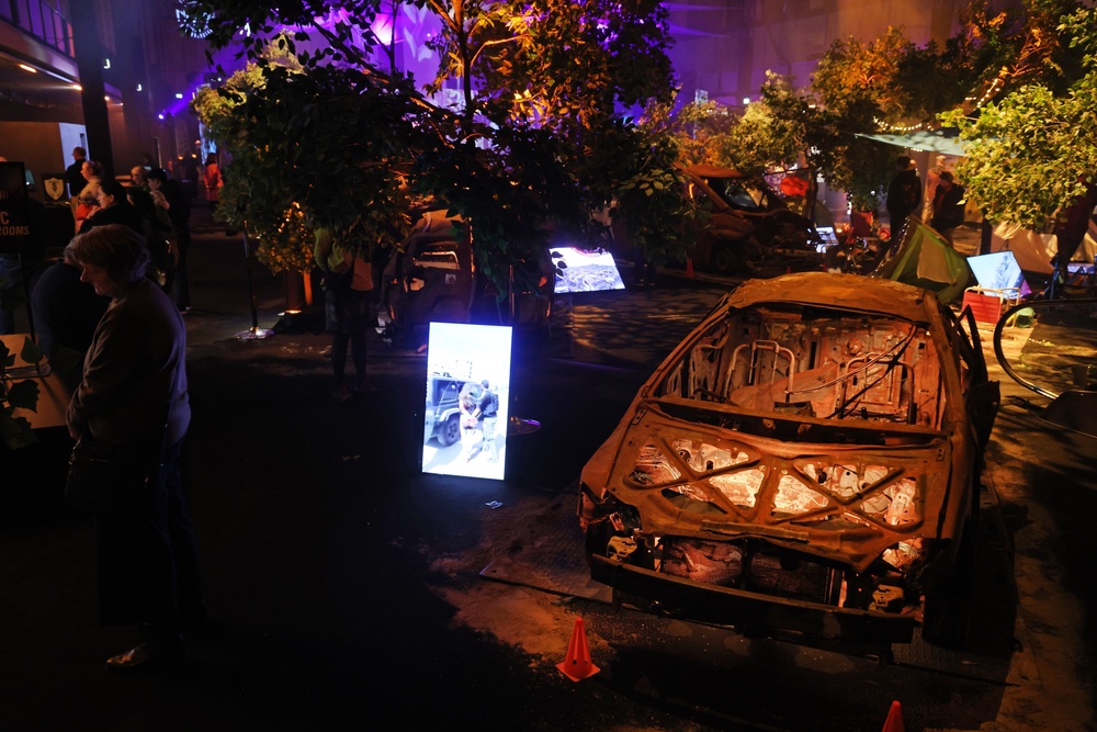 Visitors walk among burnt out cars and tents at the Nova Music Festival Exhibition in Berlin, Germany. (Getty Images)
