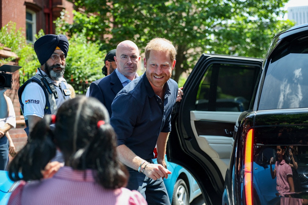 Britain's Prince Harry greets a child as he leaves the Birmingham Children's Hospital after celebrating the 20th anniversary of the first WellChild Nurse programme (Reuters)