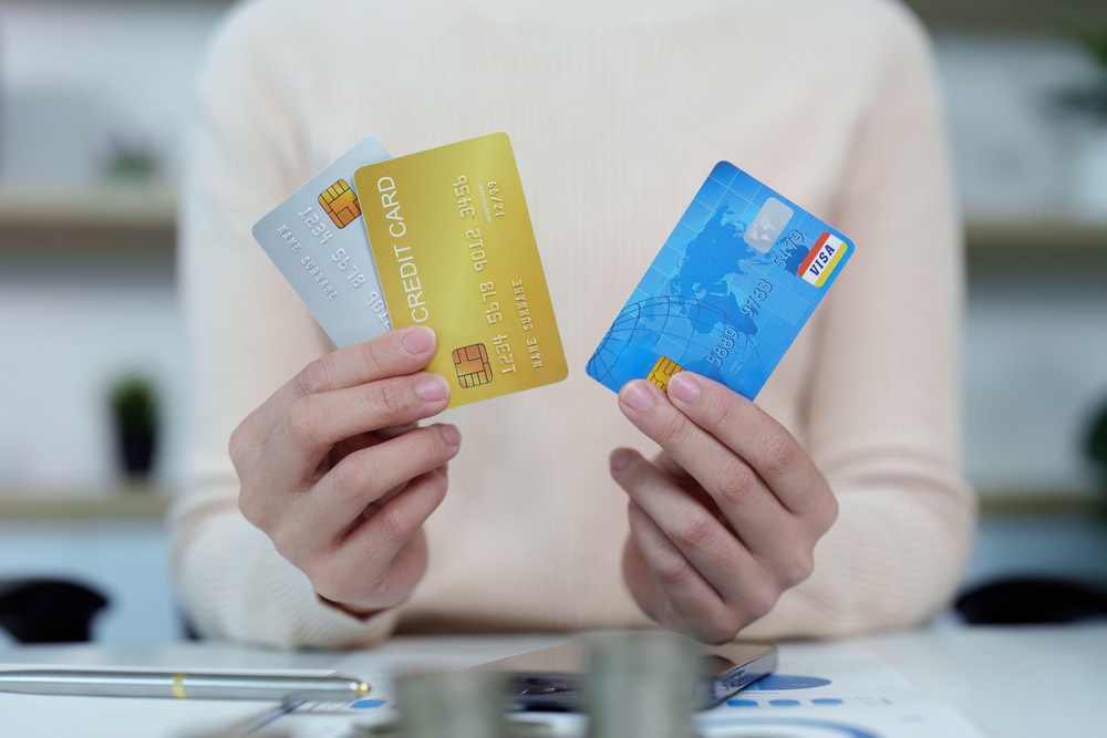 Woman holding three credit cards (Alamy/PA) (Alamy/PA)