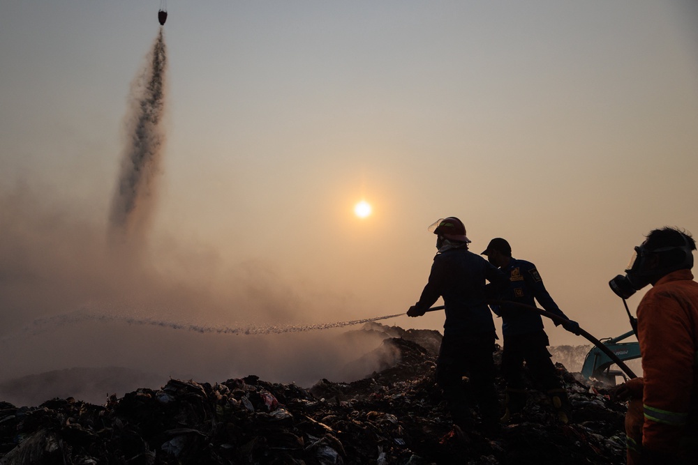Firefighters and members of Indonesia's National Disaster Management Agency extinguish remaining fire at the Jatiwaringin landfill in Tangerang (AFP/Getty)