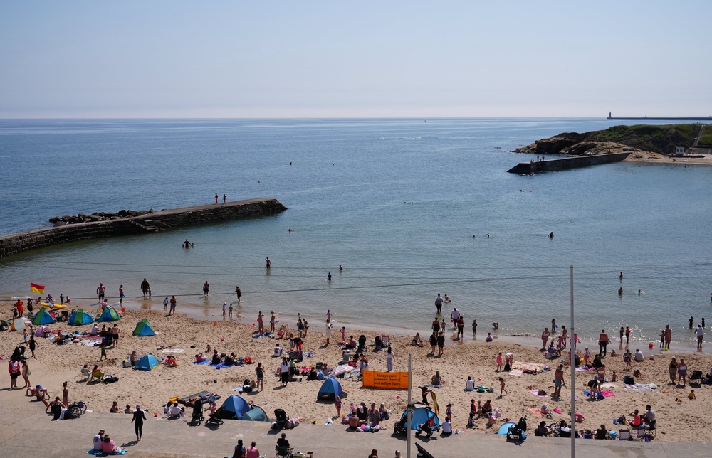 People enjoying the hot weather on the coast at Cullercoats Bay in North Tyneside (Owen Humphreys/PA) (PA Wire)