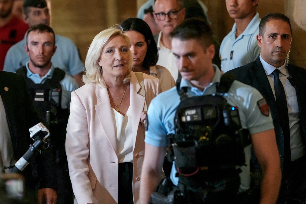 Marine Le Pen (C-L) leaves after the verdict in the appeal trial of RN former or actual members on charges of embezzlement of European public funds in a case of alleged European Parliament fake jobs at Paris Court of Appeal on July 7, 2026 (AFP/Getty)