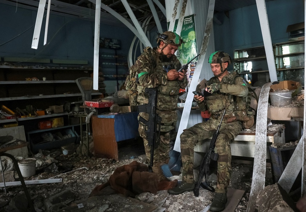 Servicemen of the 49th Separate Assault Battalion Carpathian Sich of the Ukrainian Armed Forces use a drone detector as they hide inside a damaged store during their combat mission, amid Russia's attack on Ukraine, in the frontline town of Druzhkivka, in Donetsk region, Ukraine July 9, 2026. (Reuters)