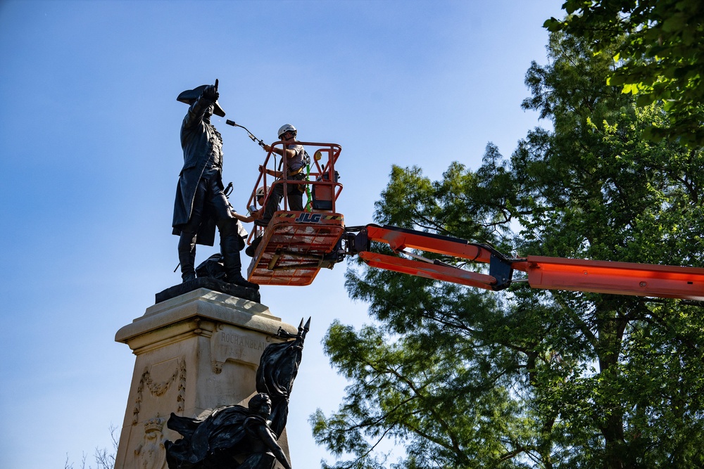 National Park Service employees paint and repair the Major General Comte Jean de Rochambeau bronze statue honoring a French nobleman and general who played a major role in helping the 13 Colonies win independence during the Revolutionary War, in Lafayette Park in Washington, DC, on July 2, 2024. (AFP/Getty)