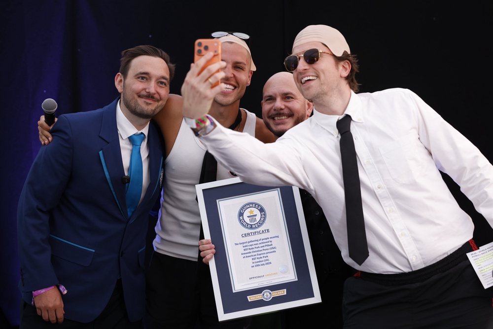 Greg James takes a photo of Pitbull, Jack Remmington and Will Munford after the rapper was presented with a Guinness World Record certificate (David Parry/PA) (PA Wire)