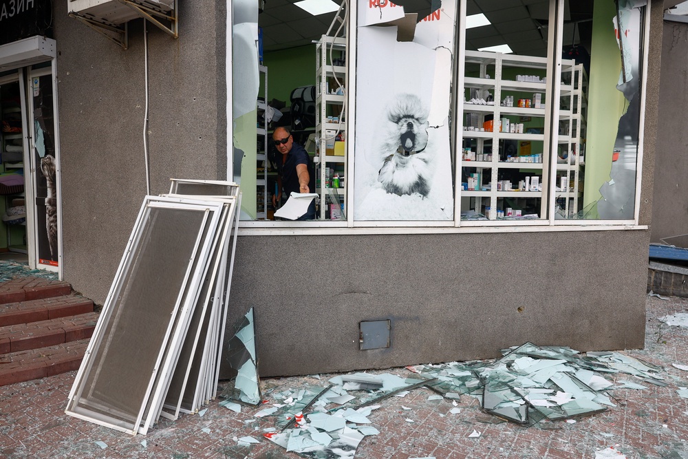 A resident removes debris from his pet shop, which was damaged during Russian missile strikes (Reuters)