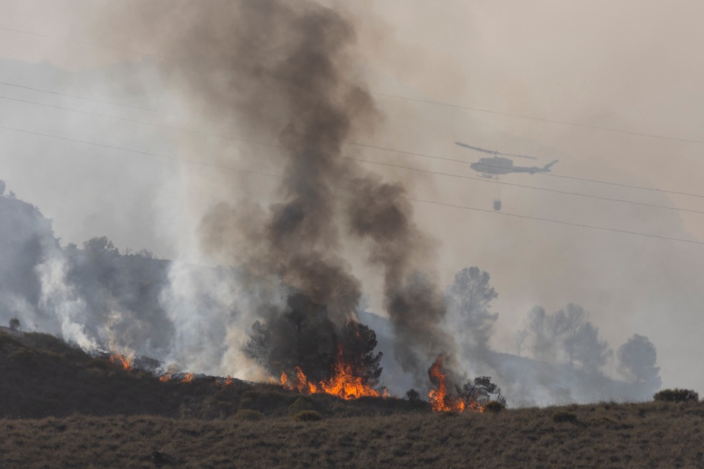A helicopter drops water as flames and smoke rise from a wildfire near the municipality of Los Gallardos (Getty)