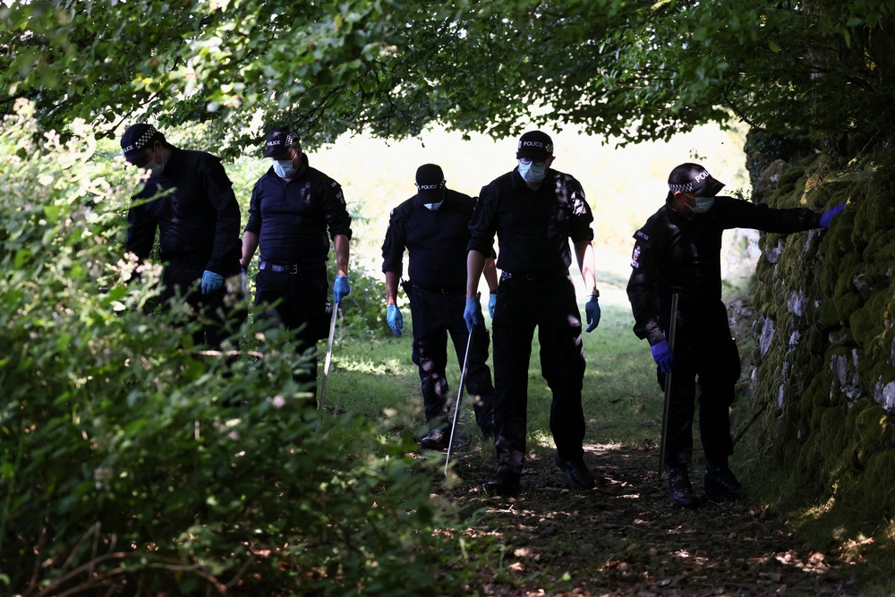 Police officers investigate the area near the home of Ann Widdecombe on Saturday (Reuters)