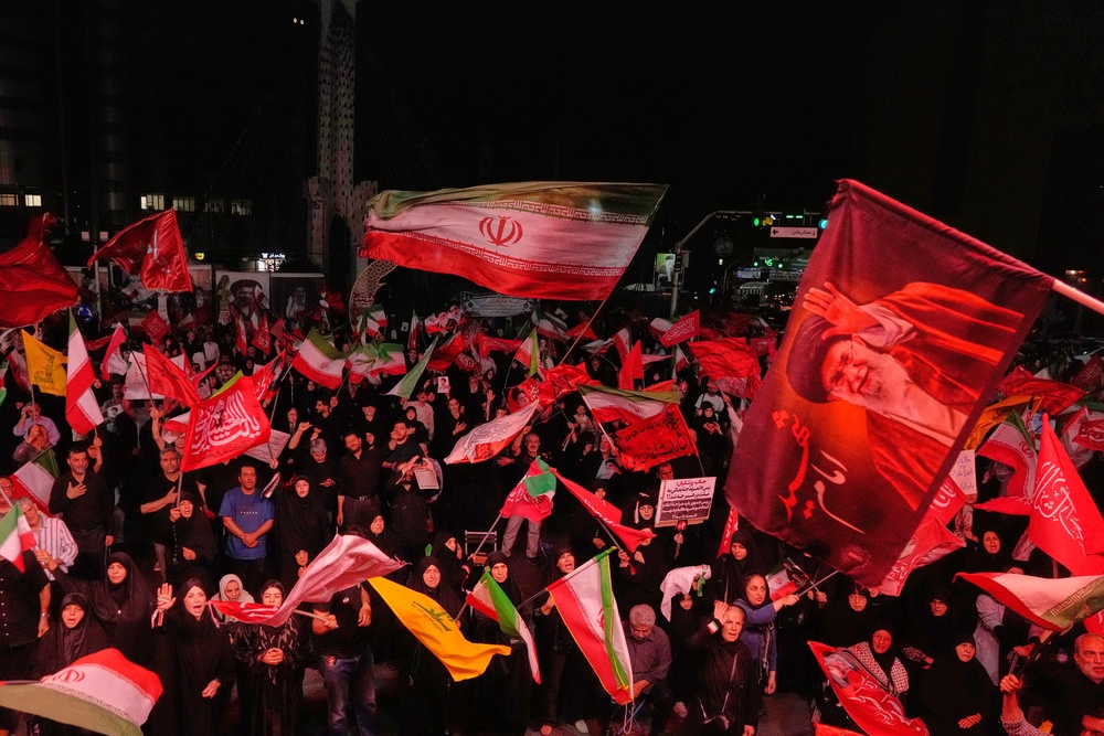 Pro-government demonstrators wave Iranian and religious flags in a gathering commemorating the late Iranian Supreme Leader Ayatollah Ali Khamenei, shown in a flag at right, at a square in Tehran, Saturday, July 11, 2026. (AP Photo/Vahid Salemi) (AP)