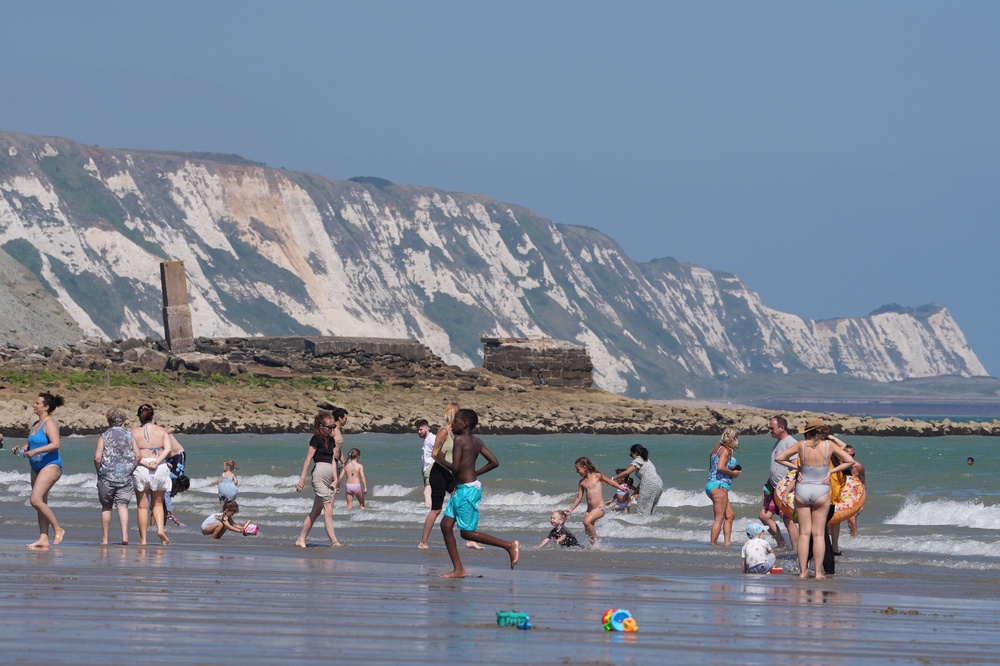 People enjoy the hot weather on Sunny Sands beach in Folkestone, Kent, on Saturday (PA) (PA Wire)