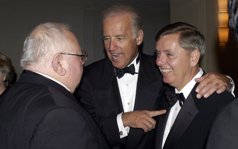 Future president and then-senator Joe Biden introduces Graham to Lee Ewing of Aerospace Daily at a black tie gala in 2004 (Getty)