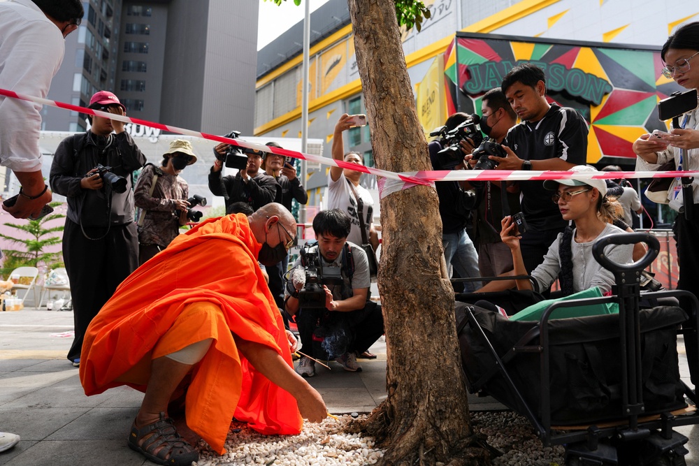 A Buddhist monk prays at the site of the deadly fire (Reuters)