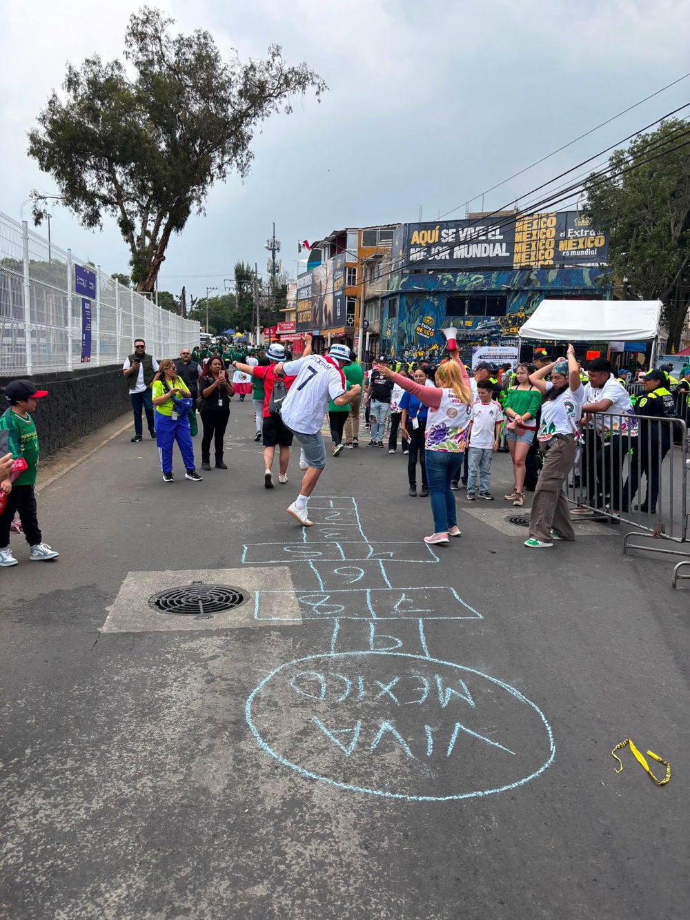 Two England fans play hop-scotch with Mexican locals outside the Estadio Azteca (Kieran Jackson/The Independent)
