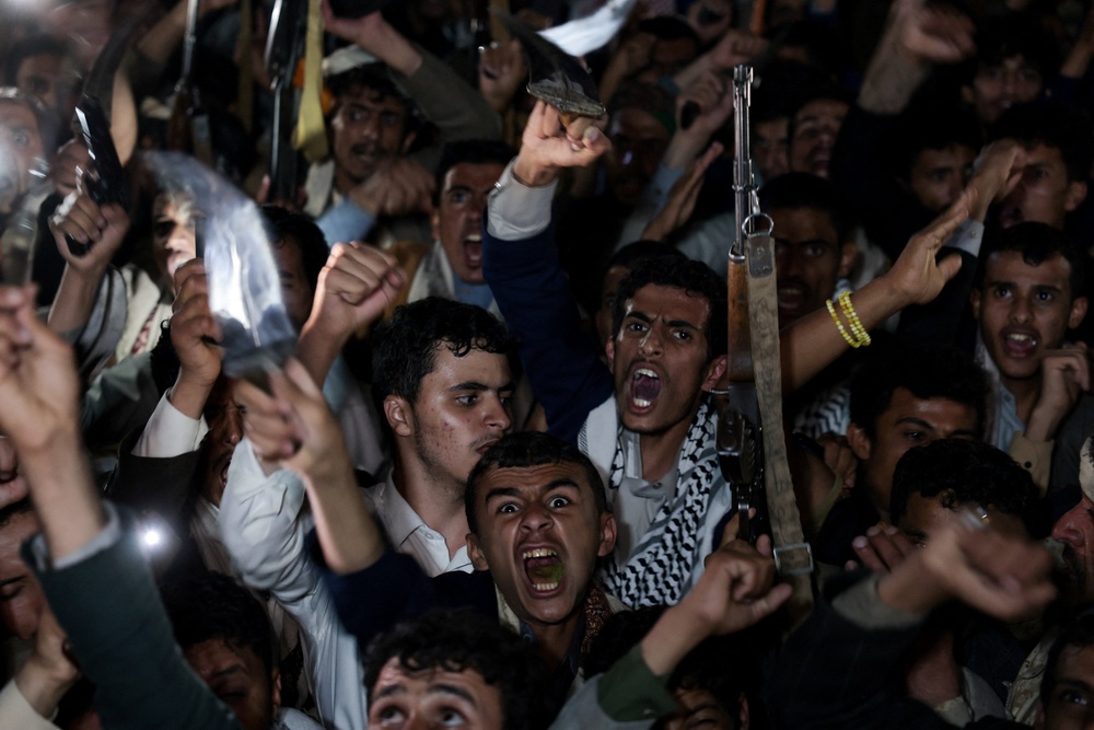 Houthi supporters shout slogans as they demonstrate against airstrikes on Sanaa International Airport (Reuters)