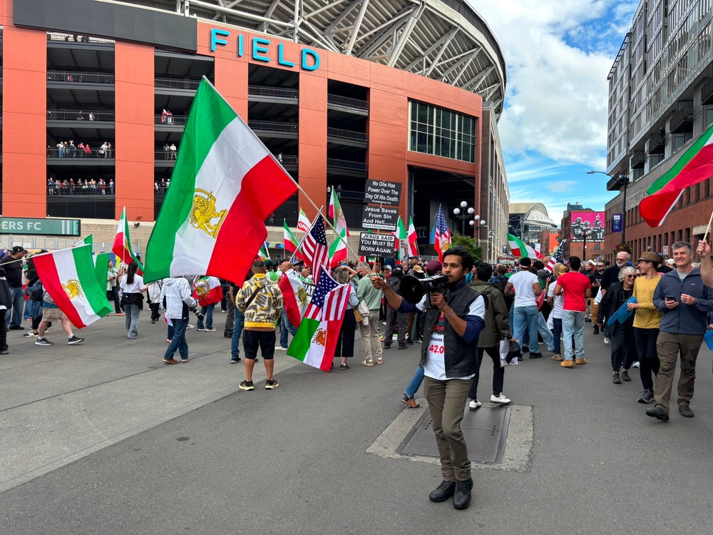 Emery, 37, an anti-Iranian regime campaigner, holding a microphone outside Lumen Field (Kieran Jackson/The Independent)
