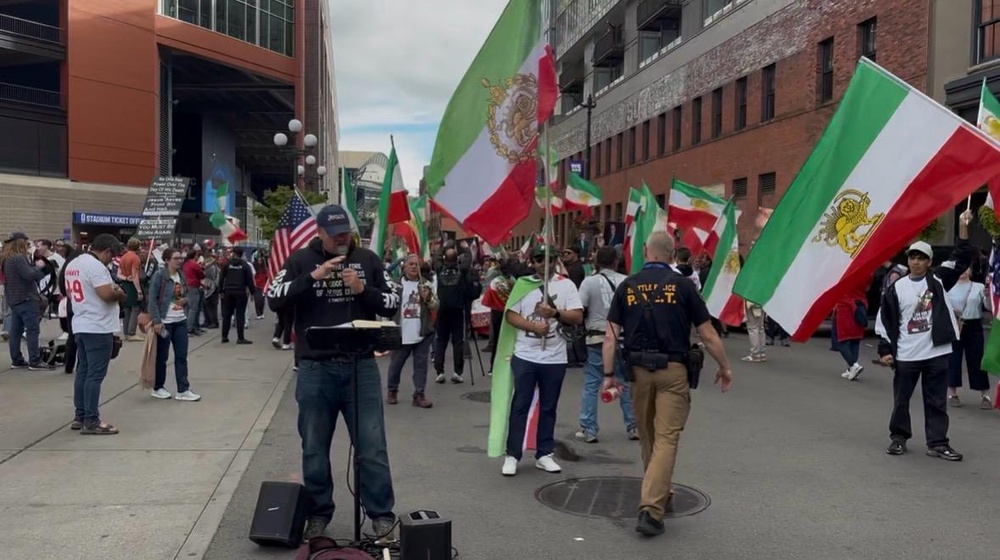 An anti-Iranian regime march comes across a Christian preacher in Seattle (Kieran Jackson/The Independent)