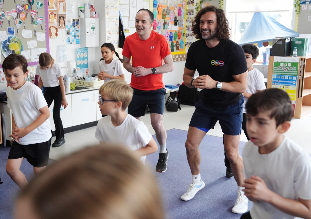 Joe Wicks and Health Secretary James Murray meet and exercise with year 2 and 3 pupils during a visit to Colindale Primary School in London to launch the fitness coach’s new series of kids’ workout programme Activate (PA)
