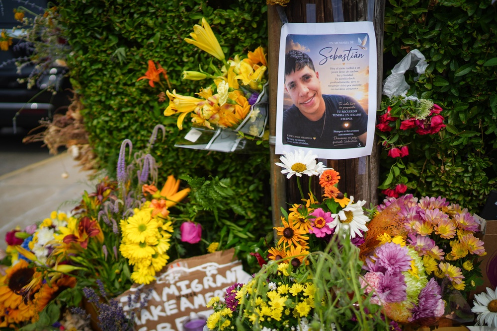 Members of the community left candles, flowers and pro-Immigrant messages at the scene where federal agents shot a Colombian native who was allegedly working in the US lawfully (Getty)