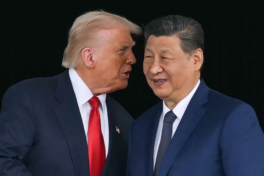 Trump (L) talks to China's President Xi Jinping as they shake hands after their talks at the Gimhae Air Base, located next to the Gimhae International Airport in Busan on October 30, 2025 (AFP via Getty Images)