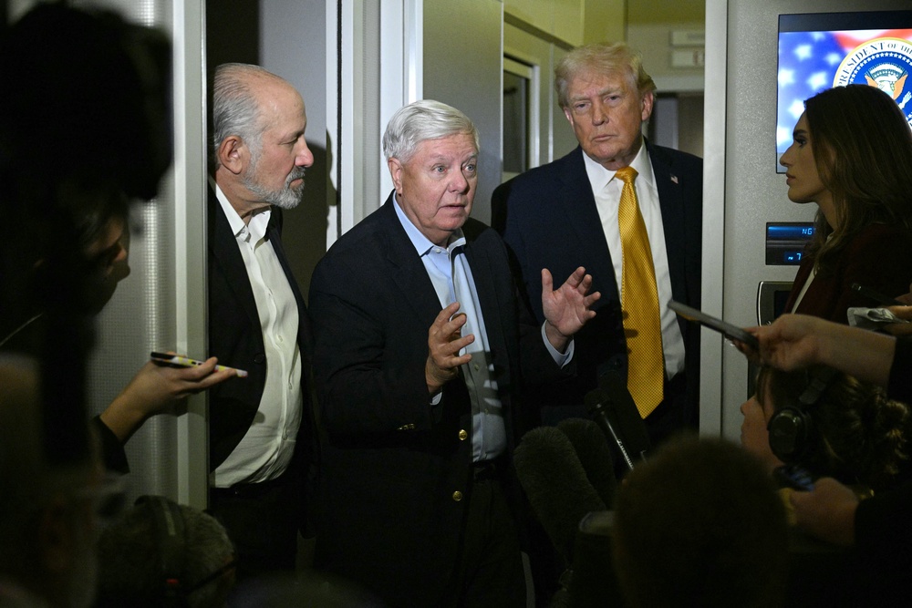 The late Sen. Lindsey Graham, flanked by President Donald Trump and Commerce Secretary Howard Lutnick aboard Air Force One on Jan. 4. (AFP/Getty)